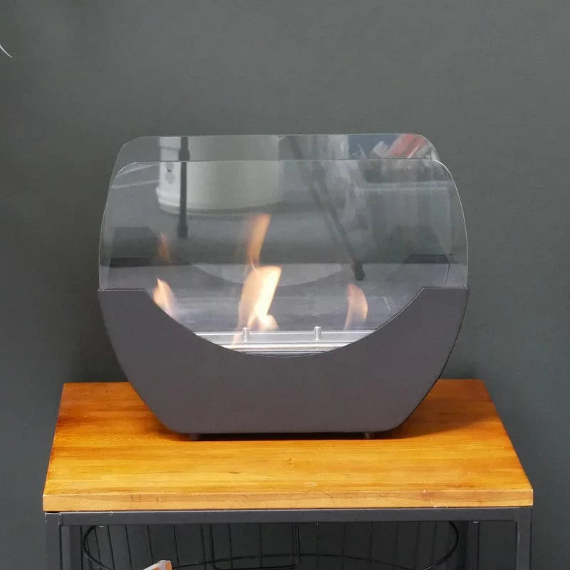 Cradle black bioethanol fireplace with a lit flame on a wooden side table